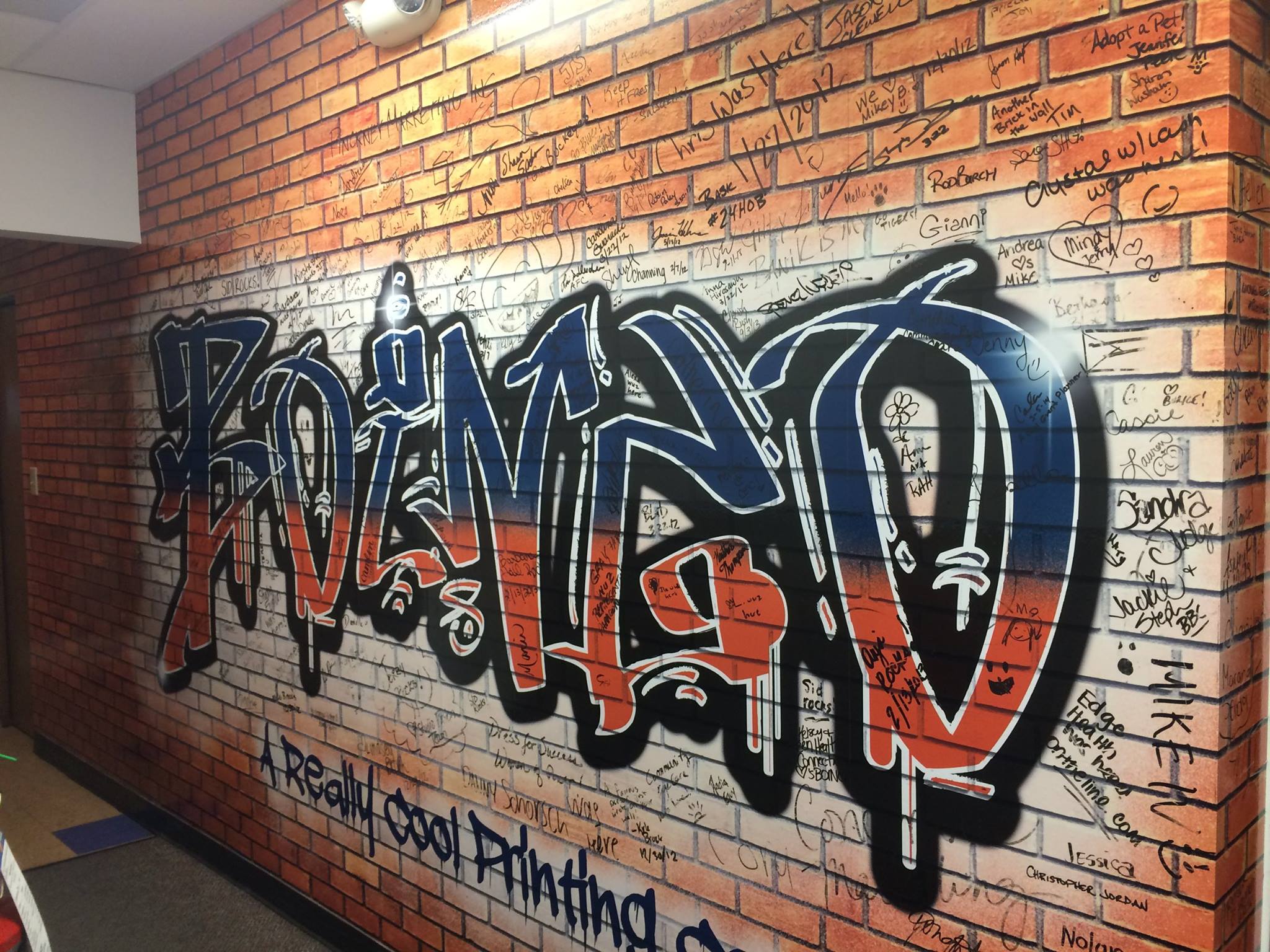 Boingo Graffiti Wall Graphic in Orange and Black on Brick Wall.